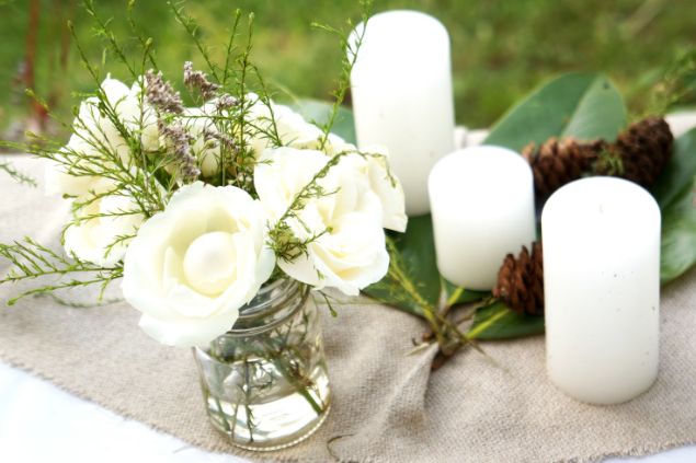 Imagem de velas e flores brancas, alguns dos elementos de oferendas para a Vovó Cambinda na Umbanda.
