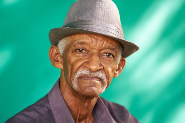 Imagem de um vovô negro de chapéu cinza, simbolizando o pai Cipriano da Umbanda.
