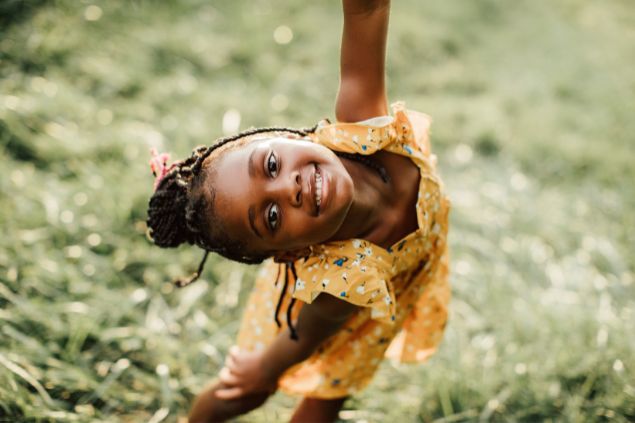 Imagem de uma criança negra, usando um vestido amarelo florido, simbolizando a erê Mariazinha.