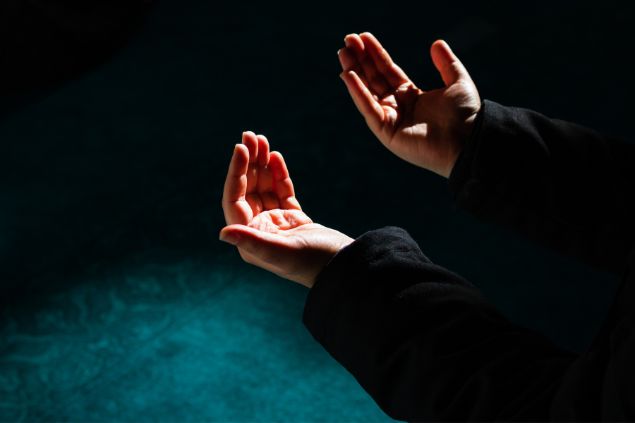 Imagem das mãos de uma mulher em sinal de oração.