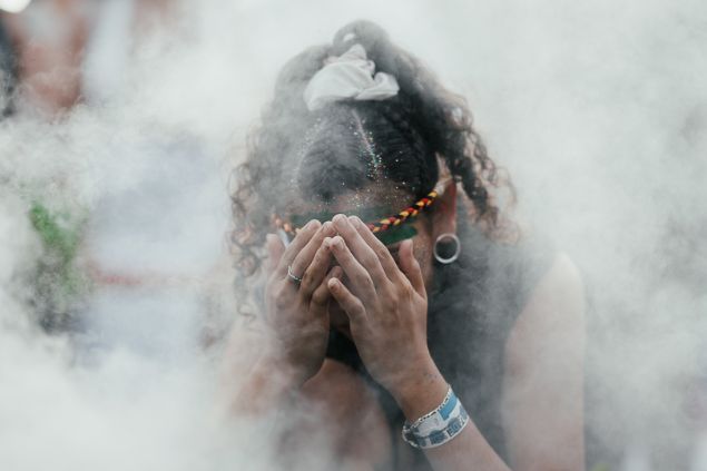 Imagem de uma mulher em um ritual em um terreiro, fazendo uma oração