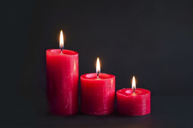 Codrut Evelina's Images / Canva Imagem de fundo preto e em destaque 3 velas acesas na cor vermelha, representando a cor de 2026.