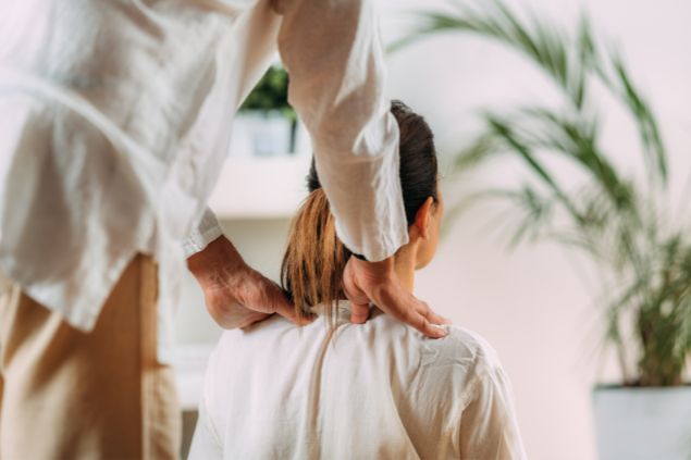 Imagem de mulher recebendo uma massagem shiatsu nas costas.
