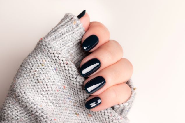 Imagem de uma mão com as unhas pintadas na cor preto.