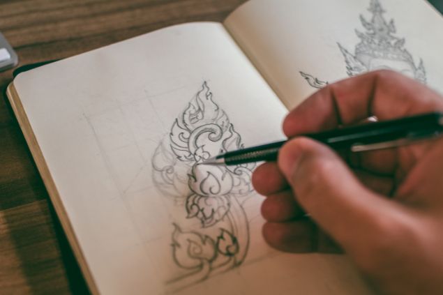 Imagem de uma pessoa fazendo uma ilustração em uma caderneta, uma das habilidades do signo de capricórnio.