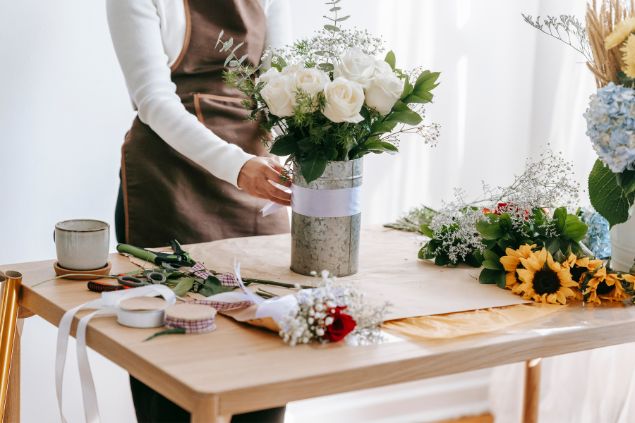 Imagem de uma mulher fazendo um lindo arranjo floral, uma das habililidades do signo de aquário.