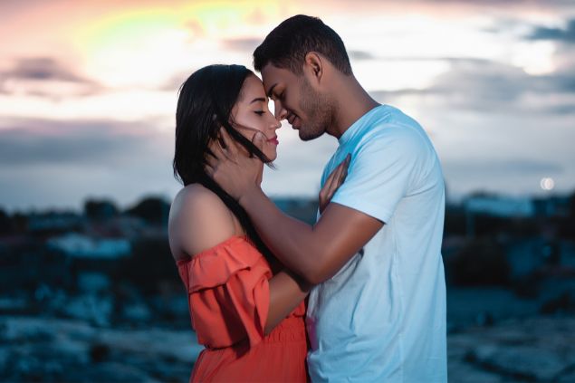 Imagem de um casal do signo de aquário e seu estilo de beijo com toques em outras partes do corpo.