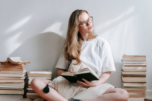 Imagem de uma mulher taurina lendo e relendo o livro, preservando pela segurança na leitura.