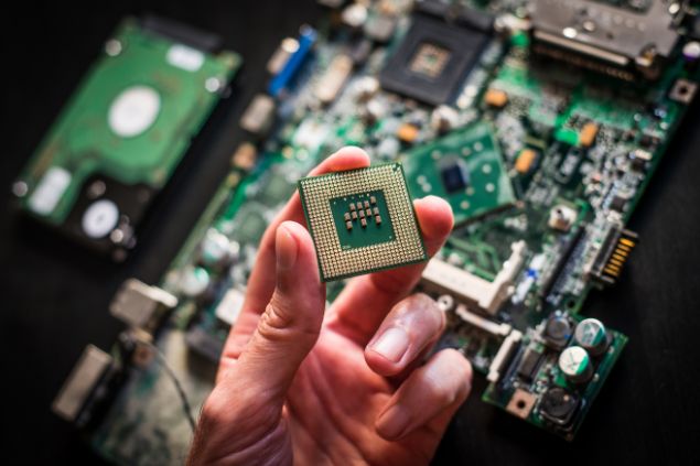 Imagem de um profissional de informática mexendo em umas peças do computador.