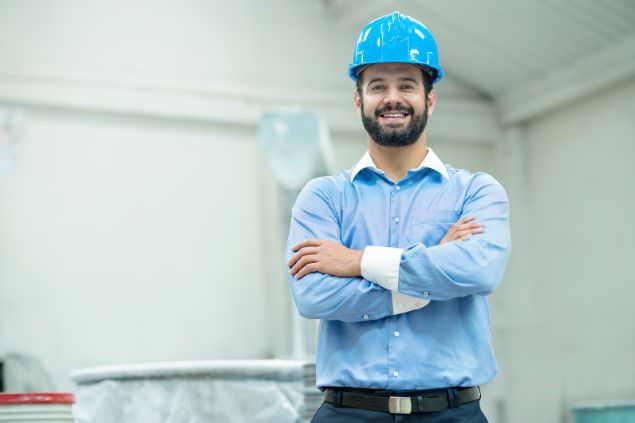 Imagem de um engenheiro usando um capacete na cor azul claro.