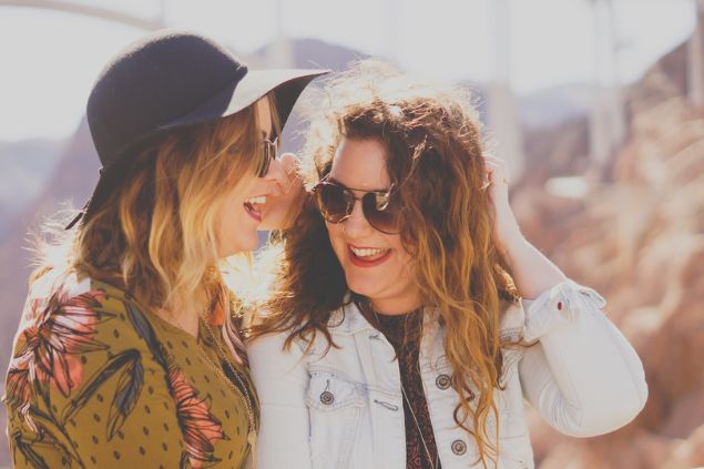 Duas mulheres alegres conversando uma com a outra.