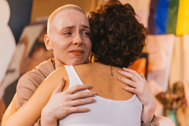 Mulher se sentindo desconfortável enquanto abraça sua colega.