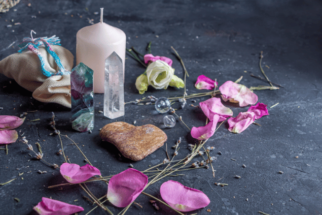 Elena Vafina / Getty Images / Canva Na imagem, há flores e cristais em cima de uma mesa. E há uma vela também.