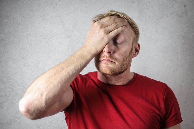 Homem com mão na cabeça e expressão de chateado