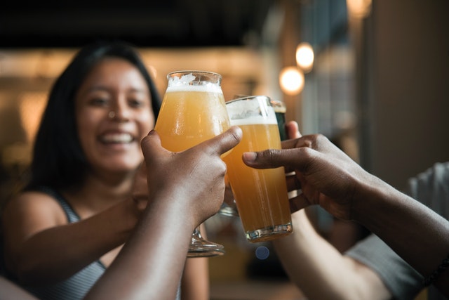 Grupo de amigos brindando com copos de cerveja.