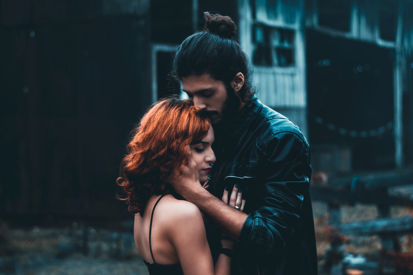 Casal de olhos fechados se abraçando na rua 