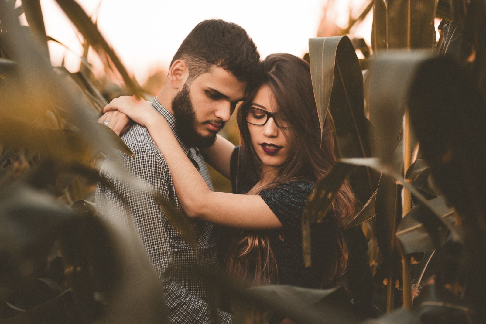 Homem e mulher abraçados em meio a plantação