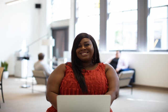 Mulher negra com expressão sorridente.