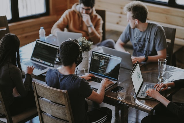 Grupo de pessoas brancas com laptops.