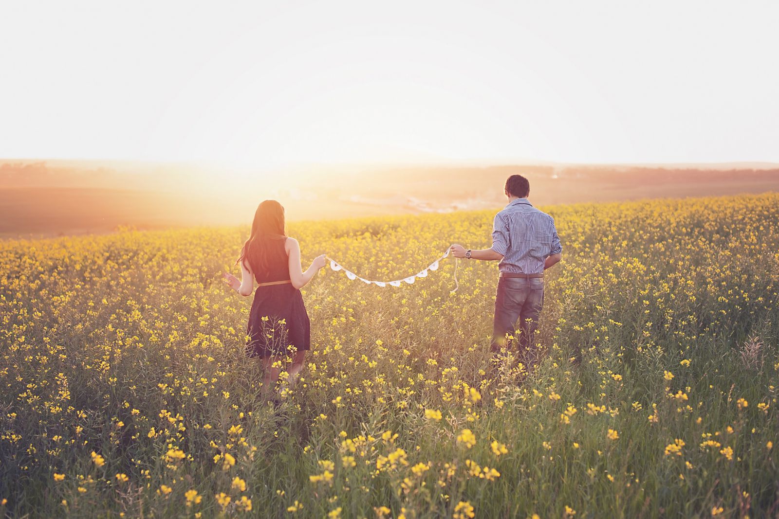 Casal caminhando em um campo de flores.