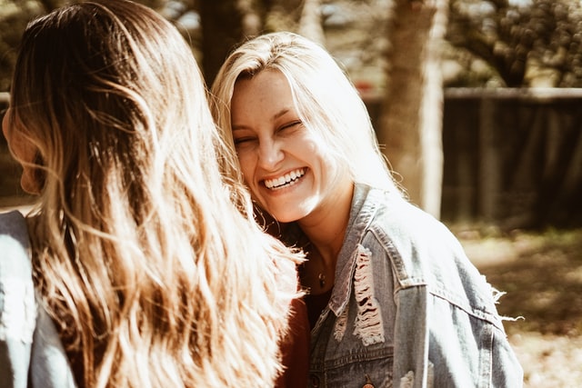 Mulher branca e loira sorrindo.