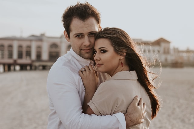 Homem e mulher brancos abraçados.