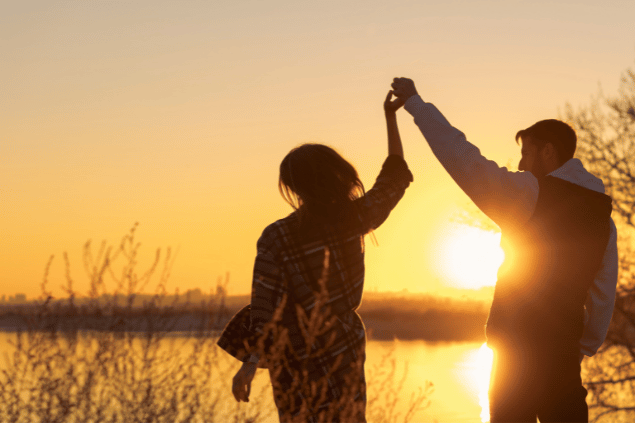 Casal de mãos dadas durante pôr do sol