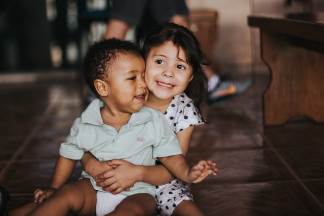 Garota com bebê no colo sorrindo