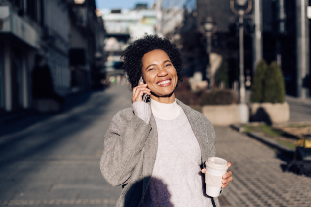 Mulher feliz na rua atendendo o celular