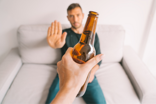 Homem rejeitando uma garrafa de cerveja