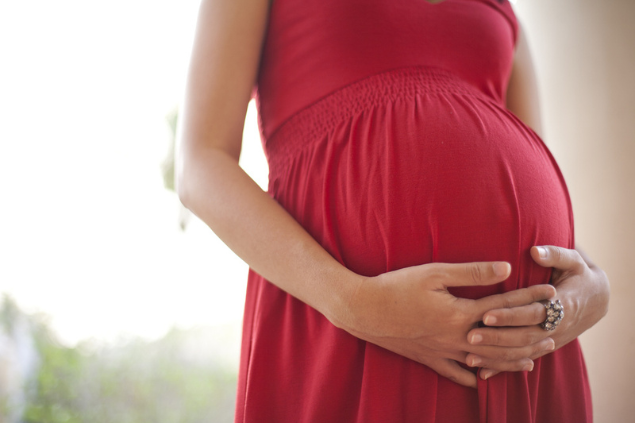 Mulher grávida colocando as mãos na barriga
