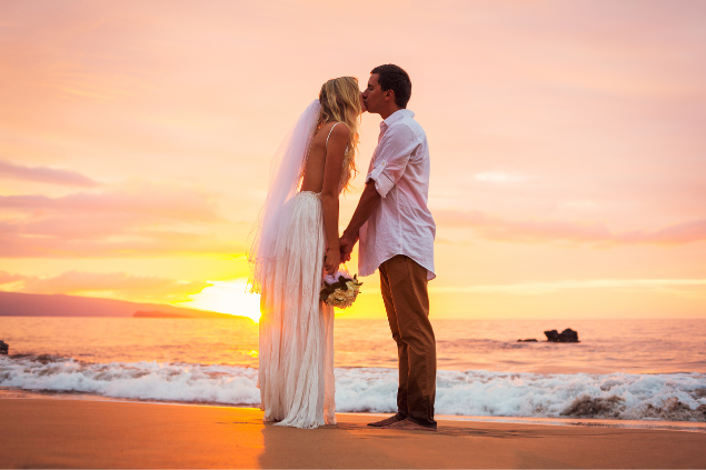 Um casal se beijando e vestido como noiva e noivo