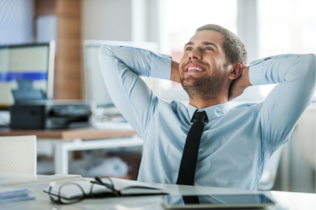 Homem feliz no trabalho, com as mãos na cabeça, sorrindo e olhando para cima