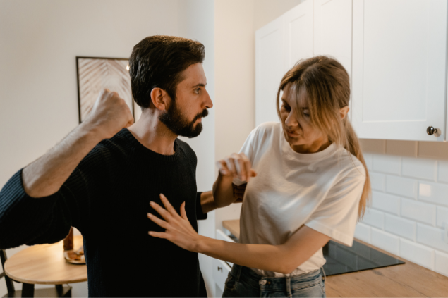 Homem ameaçando bater na mulher, com o punho apontado para ela