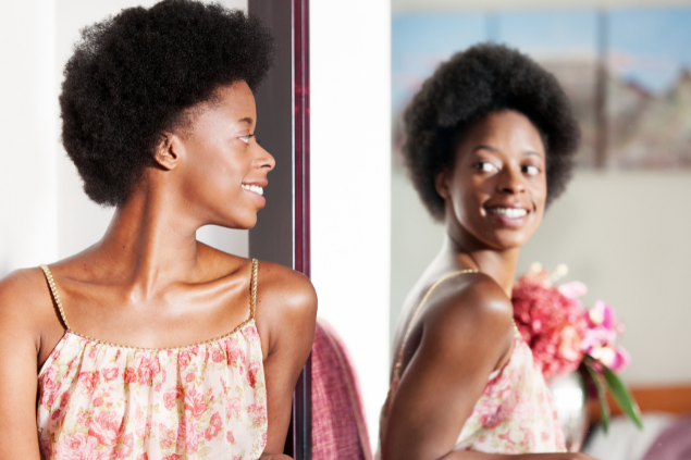 Mulher negra se olhando no espelho
