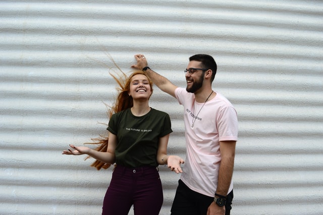 Homem e mulher brancos sorrindo.