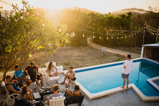 Pessoas reunidas na área externa de uma piscina.