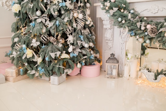 Árvore de natal com adereços pratas, azuis e dourados.