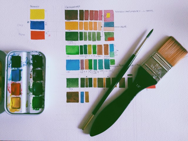 Pincéis e tintas numa mesa.
