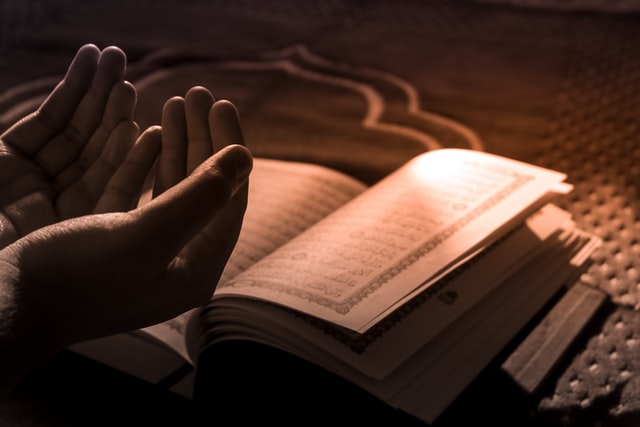 Mãos abertas em cima de livro.