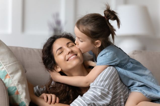 Criança beijando a bochecha da mãe