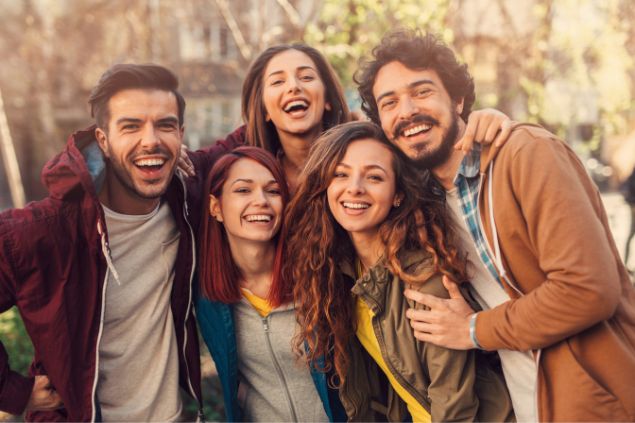 Um grupo de amigos sorrindo e olhando na câmera