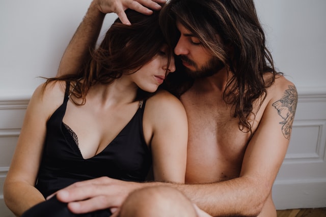 Homem e mulher brancos abraçados.