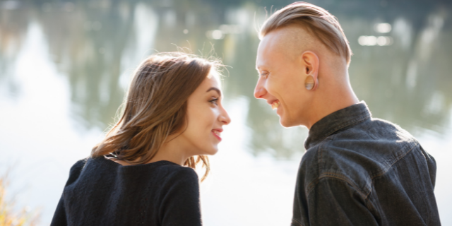 Homem e mulher conversam e sorriem. 