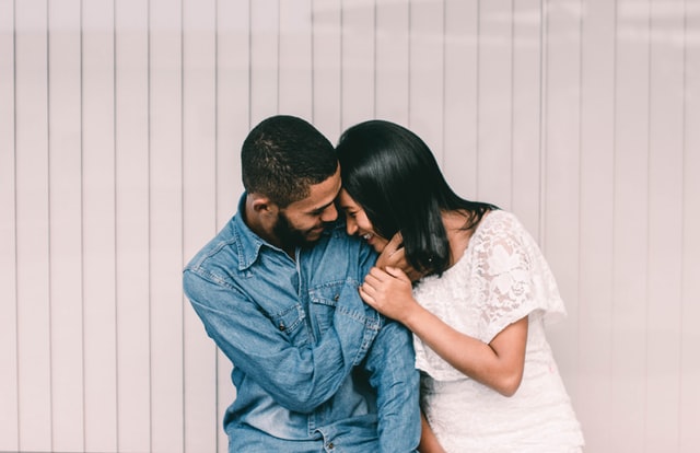 Homem e mulher abraçados, sorrindo.