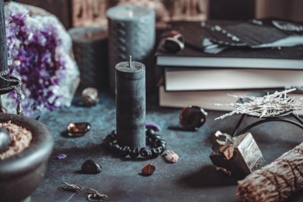 Mesa com velas, pedras e livros