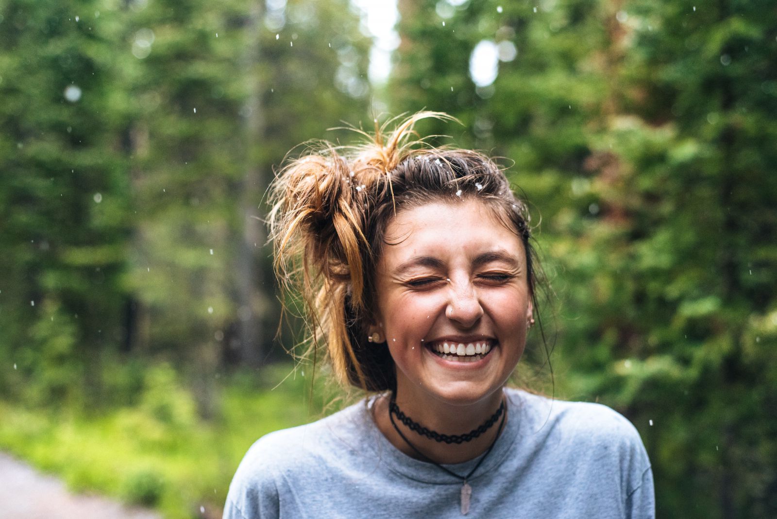 Mulher sorrindo de olhos fechados