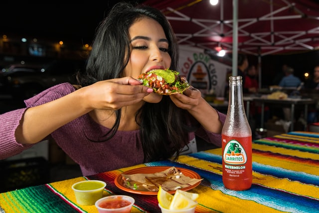 Mulher comendo tacos.