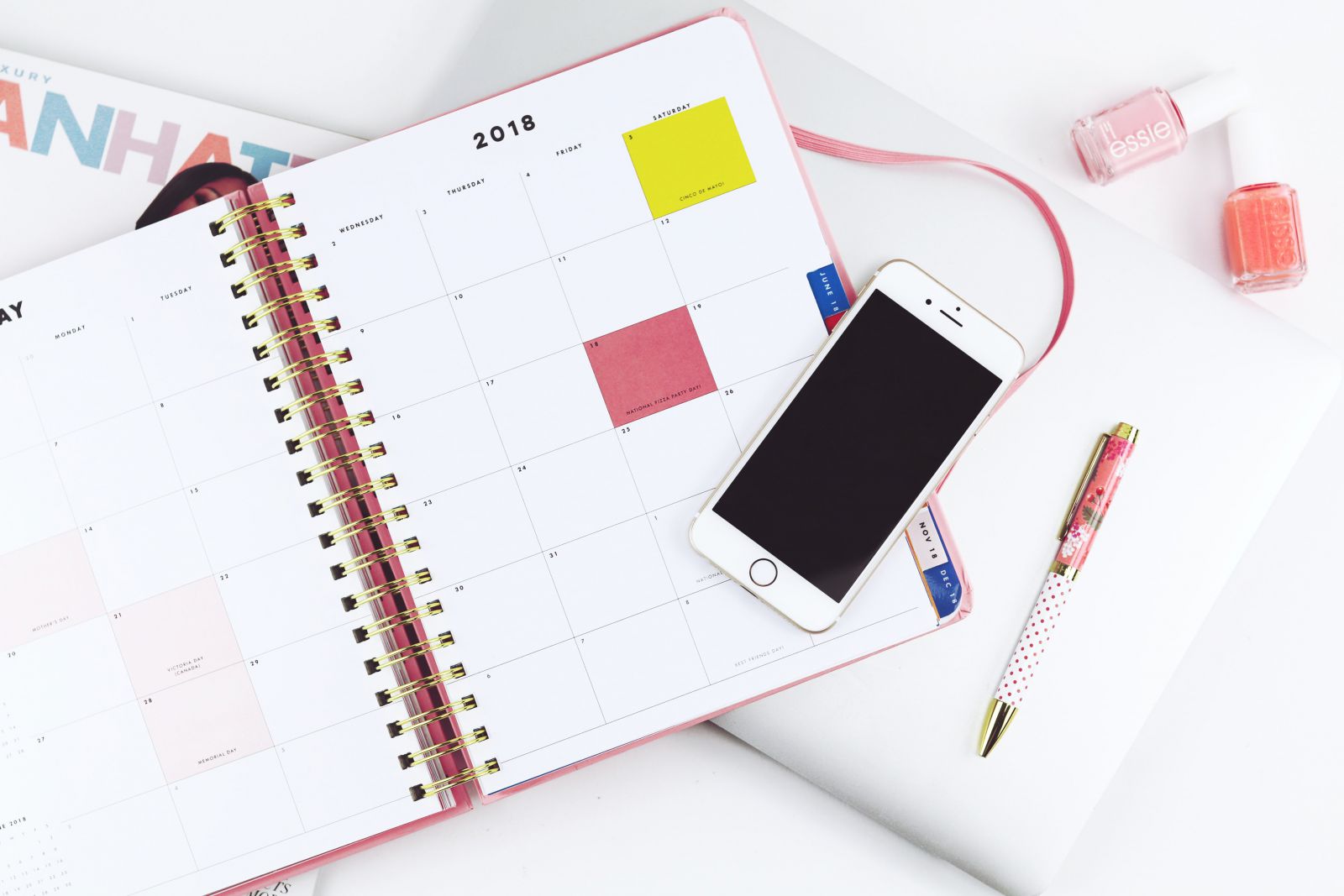 Agenda aberta com calendário e um celular em cima