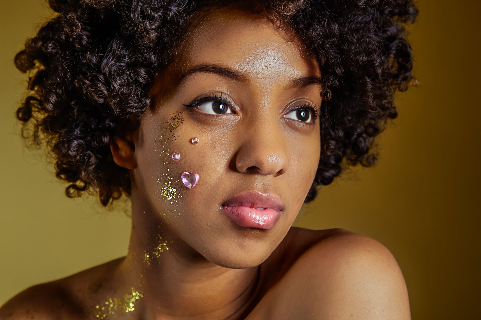 Mulher olhando para o lado pensativa com Glitter em seu rosto
